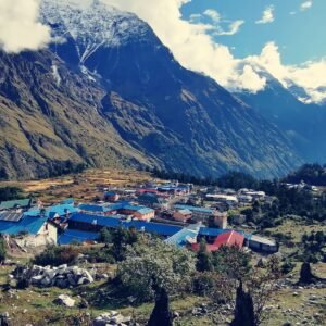Stone and slate village houses in the high Manaslu Circuit trek region of Gorkha district, Nepal, with mountain slopes rising behind